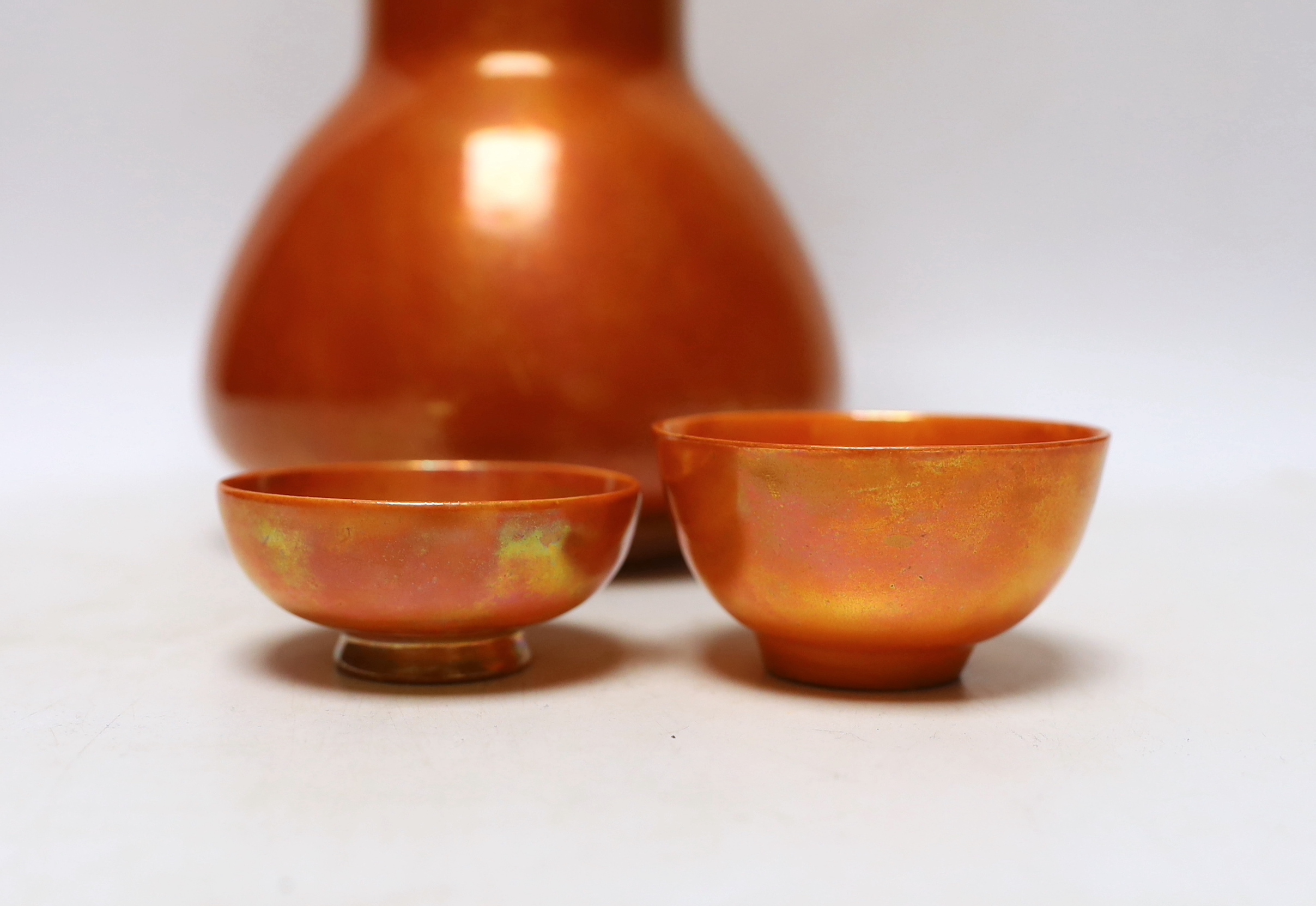 A Ruskin orange glazed vase (a.f) and three similar small bowls by Ruskin and Doulton, vase 23.5cm